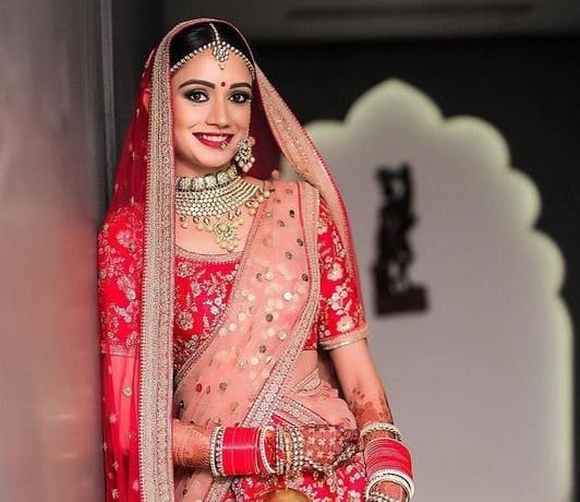 image of lehenga with one dupatta over head and one with pleats